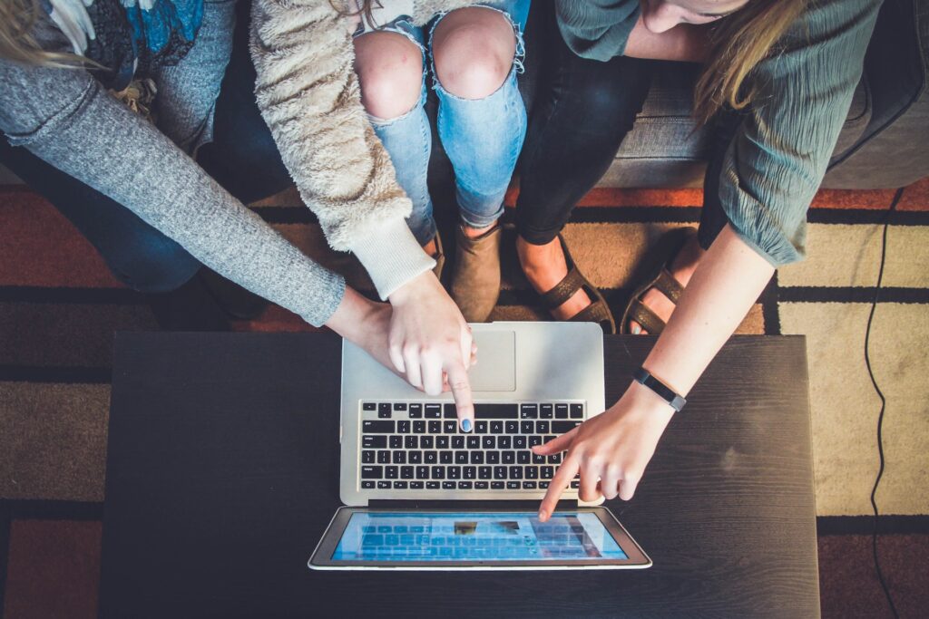 A group of women pointing at a laptop screen - to signify link building