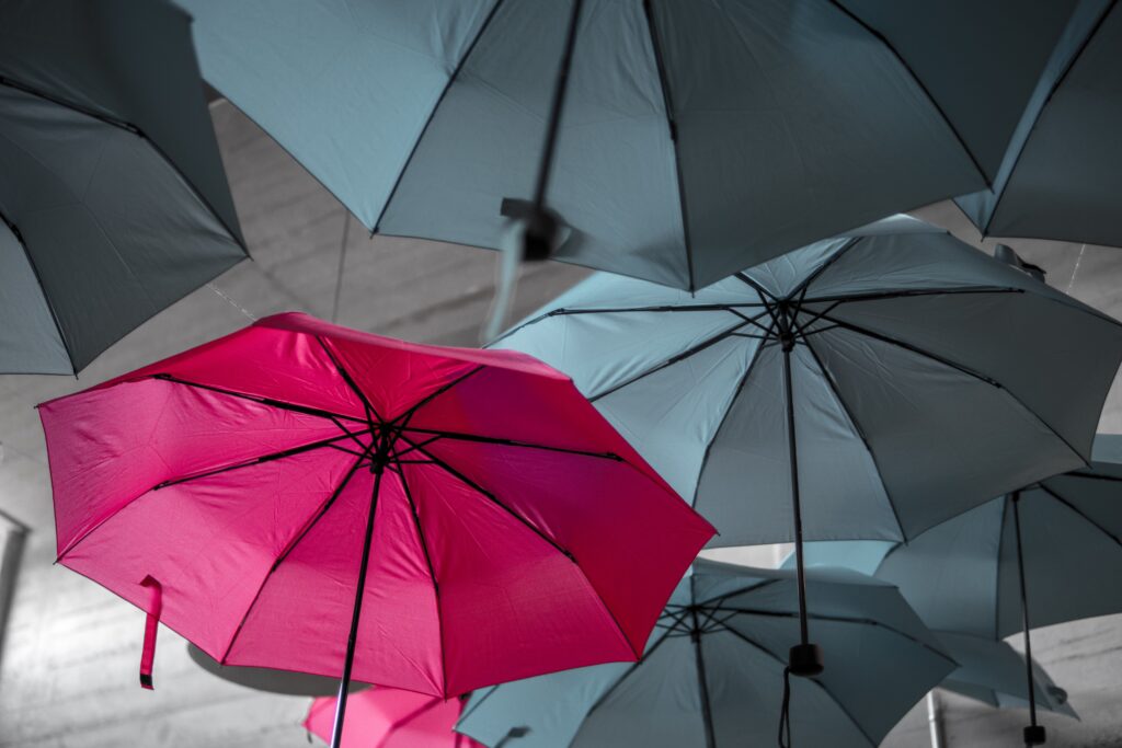 A photo of a red umbrella among a sea of grey umbrellas, to signify that content should be unique