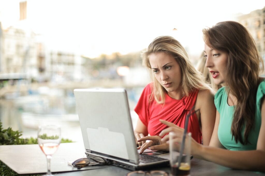 Two women discussing something that they're looking at on a laptop