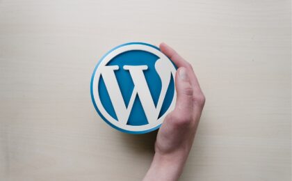 A hand curved around the WordPress logo