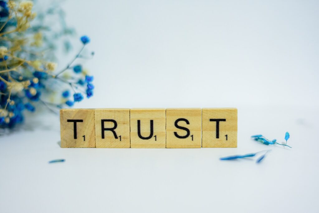 The word TRUST spelled out on wooden Scrabble tiles