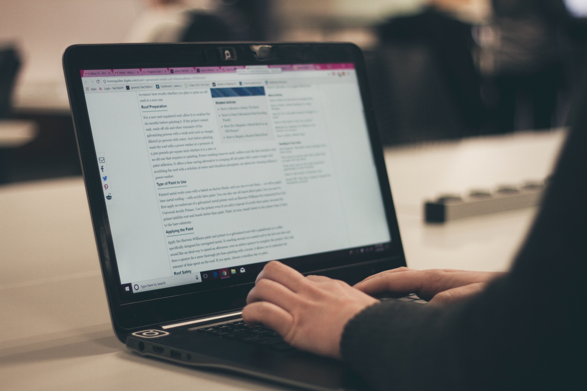 A woman's hands typing a blog post on a laptop.
